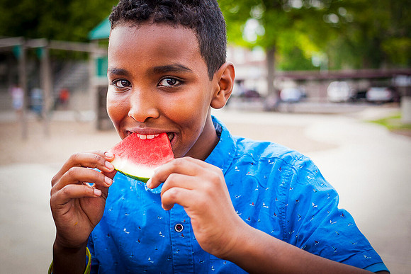 A Sudanese refugee boy eats watermelon at a picnic.