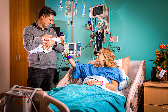 Newborn boy is held by his Dad in Alta View Hospital as Mom looks on.