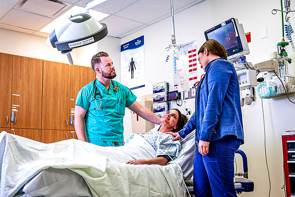 A Doctor and nurse monitor a patients recovery.