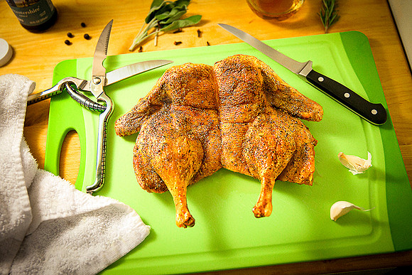 Spatchcocked roasted duck on cutting board.