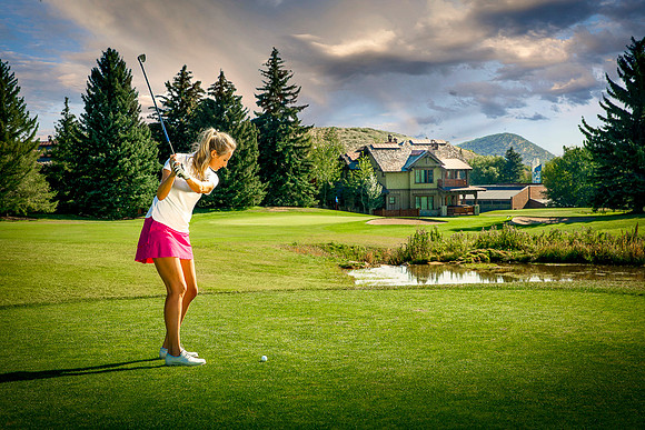 Young woman golfer tees off at Park City Golf Course.