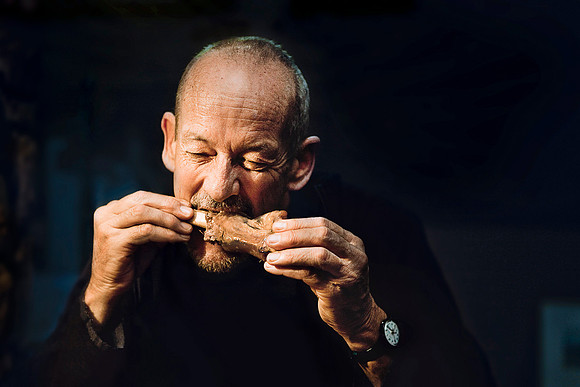 Bill Shum bites into a piece of roasted lamb meat in Brogo, New South Wales, Australia.